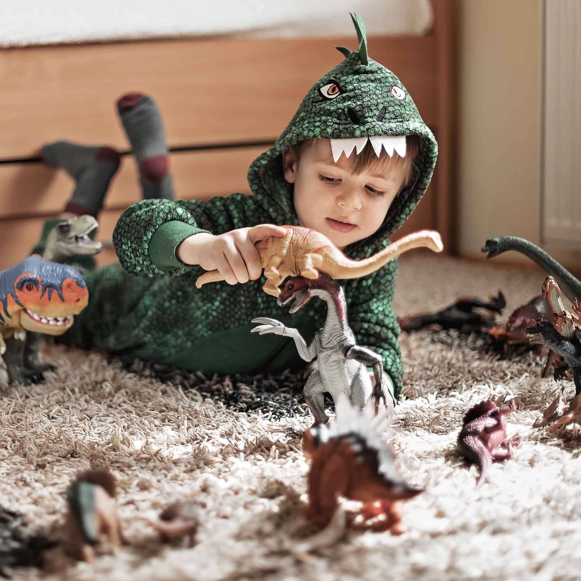 Pieni poika leikkii dinosauruksilla.